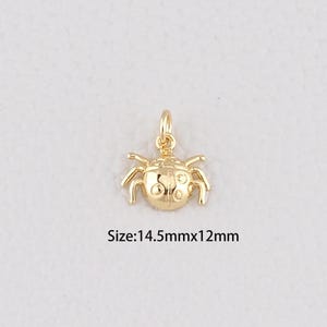 May include: A gold-colored ladybug charm with a loop for hanging. The charm has six legs and a detailed body. The text on the image reads "Size: 14.5mmx12mm".