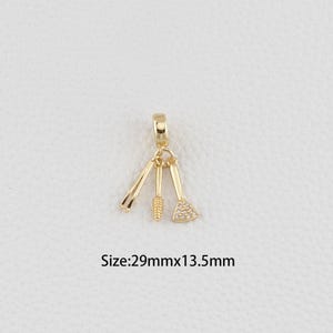 Può includere: Un ciondolo dorato con tre strumenti per il trucco: un applicatore per mascara, un pennello e un piccolo pennello angolato con una testa tempestata di strass. Il ciondolo misura 29 mm x 13,5 mm. Progettato come pendente o ciondolo.