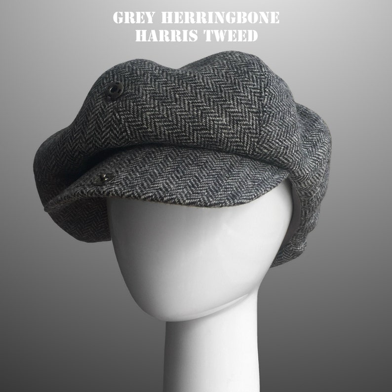May include: A grey herringbone Harris Tweed newsboy cap. The cap has a  distinctive  pattern and is made of a thick, durable fabric.
