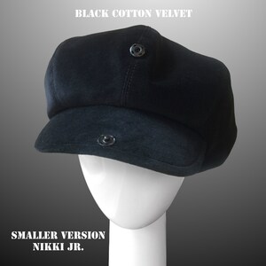 May include: Black cotton velvet newsboy cap with a button on top. The cap is on a white mannequin head. "SMALLER VERSION NIKKI JR." is written below the mannequin.