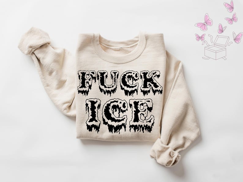 Pu&ograve; includere: Felpa color crema con la scritta "FUCK ICE" in un font nero gocciolante. Il disegno &egrave; centrato sulla parte anteriore del capo. Le maniche sono arrotolate. Farfalle rosa e un'illustrazione di una scatola sullo sfondo.