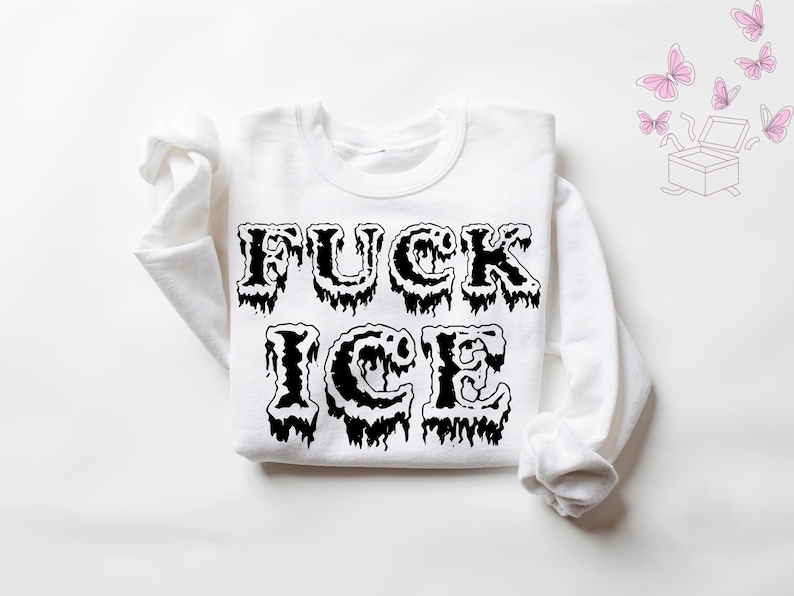Pu&ograve; includere: Felpa bianca con la scritta "FUCK ICE" in grandi lettere nere gocciolanti. La parte superiore a maniche lunghe &egrave; stesa, con il testo ben visibile sul petto. Farfalle rosa e una grafica a scatola sullo sfondo.