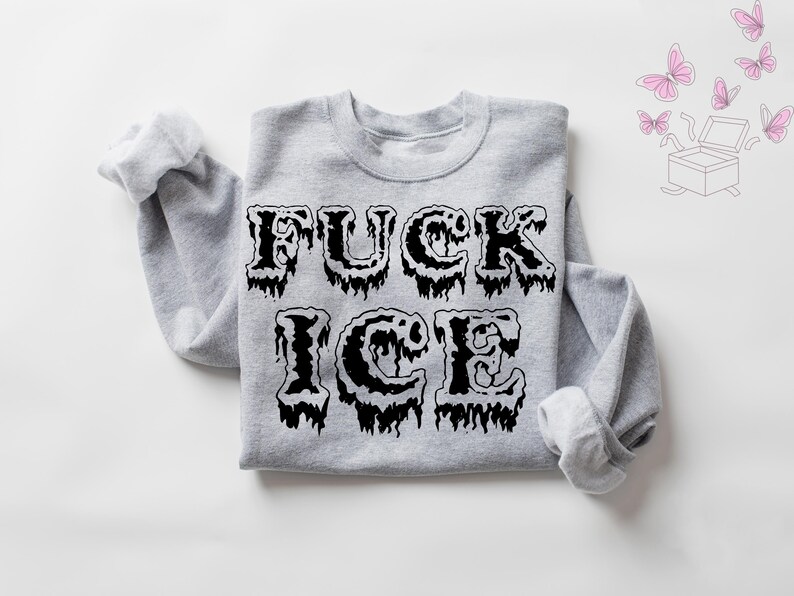 Pu&ograve; includere: Una felpa grigio melange con la scritta "FUCK ICE" stampata a grandi lettere nere gocciolanti. La felpa ha maniche lunghe e girocollo. Farfalle rosa e una grafica a scatola nell'angolo in alto a destra.