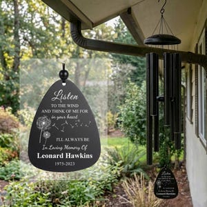 Peut inclure: Un carillon à vent noir avec un pendentif en forme de goutte portant le texte blanc : Listen TO THE WIND AND THINK OF ME FOR in your heart I'LL ALWAYS BE In Loving Memory Of Leonard Hawkins 1975-2023, avec un motif de pissenlit.