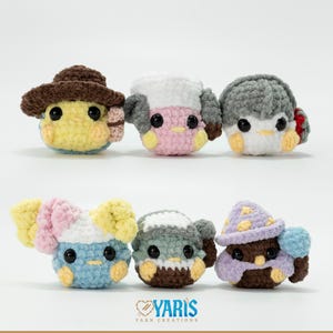 May include: A collection of six crocheted bird-like creatures, each with unique hats and accessories. The birds are in various colors, including yellow, pink, blue, and gray, with black eyes and yellow beaks. The hats include a cowboy hat, a winter hat, and a wizard hat.