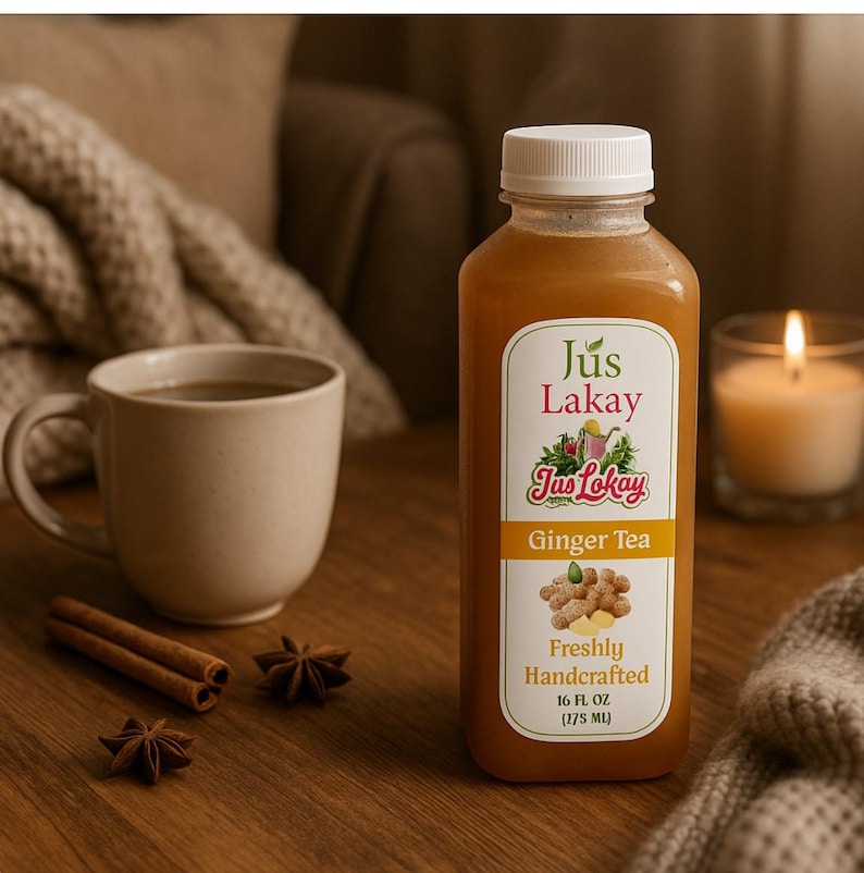 Peut inclure: Une bouteille de Jus Lakay Ginger Tea avec un bouchon blanc, &agrave; c&ocirc;t&eacute; d'une tasse de th&eacute;, de b&acirc;tons de cannelle, d'anis &eacute;toil&eacute; et d'une bougie allum&eacute;e. L'&eacute;tiquette indique "Freshly Handcrafted" et la bouteille contient 275 ml de th&eacute;.