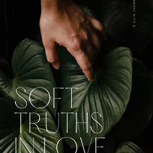 May include: A hand hovers over large, dark green leaves. The image features the text "SOFT TRUTHS IN LOVE" in a delicate font, with additional text below. The overall aesthetic is natural and serene.