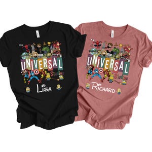 Op de afbeelding: Twee T-shirts, &eacute;&eacute;n zwart en &eacute;&eacute;n stoffig roze, met een kleurrijk grafisch ontwerp. Het ontwerp bevat de tekst "UNIVERSAL Studios" en verschillende stripfiguren. Het zwarte shirt heeft de naam "Lisa" en het stoffig roze shirt heeft de naam "Richard".