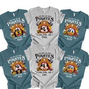 Peut inclure: Un ensemble de six t-shirts &agrave; manches courtes en gris chin&eacute; et bleu sarcelle. Chaque t-shirt pr&eacute;sente un personnage de dessin anim&eacute; portant un chapeau de pirate et un cache-&oelig;il, avec le texte YO HO YO HO PIRATES LIFE FOR ME et un nom.