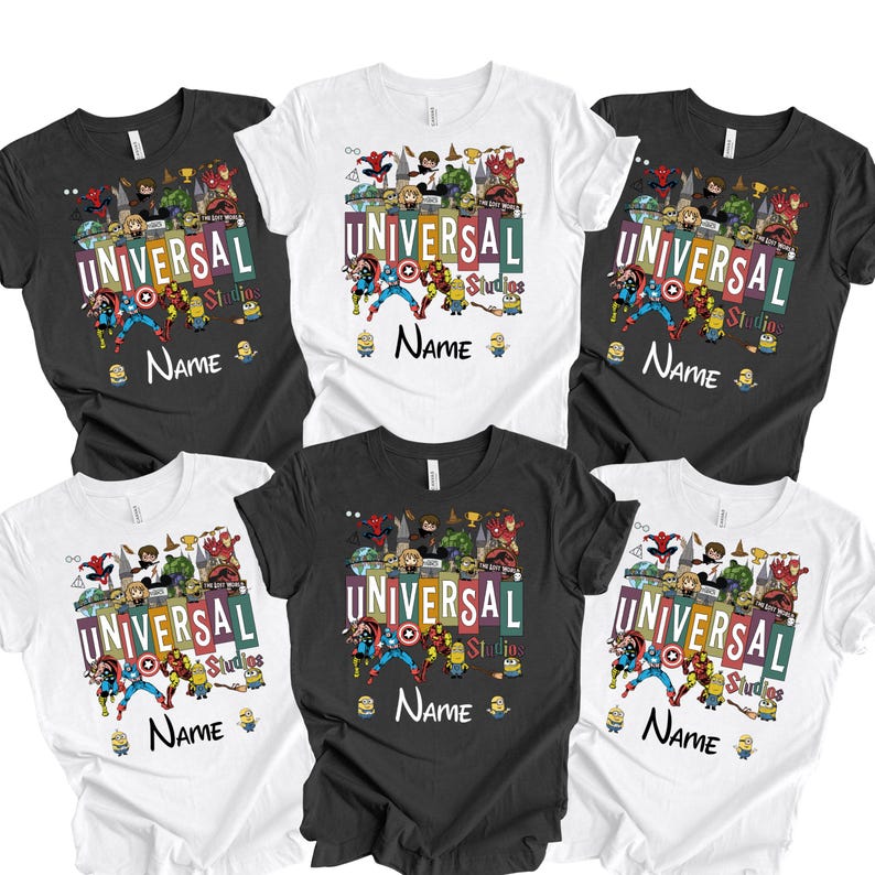 Op de afbeelding: Een verzameling zwarte en witte t-shirts, elk met een kleurrijk grafisch ontwerp. Het ontwerp bevat de tekst "UNIVERSAL Studios" en "NAME", samen met verschillende stripfiguren. De shirts zijn korte mouwen.