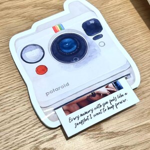 May include: A white Polaroid-style sticker with a rainbow stripe and the word "polaroid". The sticker has a photo print with the text "Every memory with you feels like a Snapshot I want to keep forever."