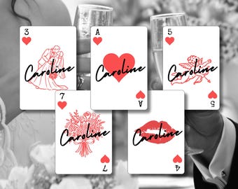 May include: A collection of playing cards with red suit symbols and the name "Caroline" in cursive. Each card features a different design, including a heart, a couple, an angel, a bouquet, and lips.
