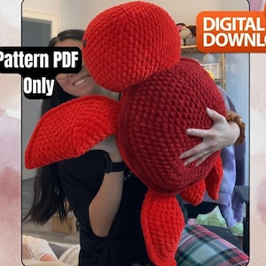 Puede incluir: Una gran tortuga roja de ganchillo. La tortuga tiene un cuerpo redondo, cabeza y aletas. La imagen incluye el texto "Pattern PDF Only" y "Digital Download".