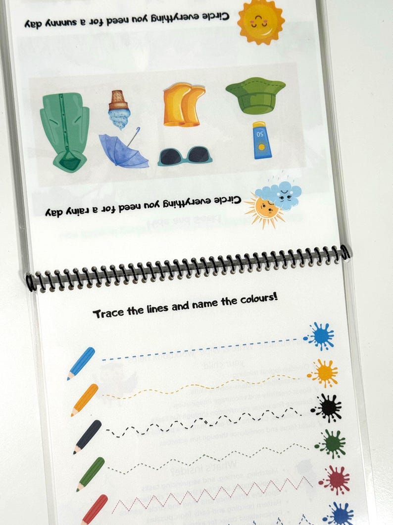 May include: A spiral-bound educational activity sheet featuring two sections. The top section shows illustrations of a green raincoat, ice cream, yellow boots, a green hat, a blue umbrella, sunglasses, and sunscreen with text prompts. The bottom section displays colored pencils and dashed lines leading to paint splatters with the text Trace the lines and name the colours!