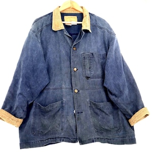 May include: A long-sleeve blue jacket featuring a tan corduroy collar and matching tan corduroy cuffs. The jacket has a button-front closure, one chest pocket on the left side, and two large patch pockets at the waist. The fabric has a faded finish.