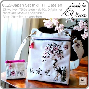 Puede incluir: Conjunto de bolso bandolera blanco y pequeña bolsa con bordados de inspiración japonesa. El bolso presenta una grulla, flores de cerezo y caracteres japoneses. La pequeña bolsa tiene bordada la palabra "Love". El bolso tiene cremallera y borla rosas.