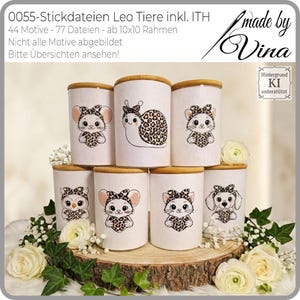 Könnte beinhalten: Sieben weiße zylindrische Behälter mit Holzdeckeln, jeder mit einem anderen Tierdesign, das ein Herz mit Leopardenmuster hält. Zu den Tieren gehören eine Maus, eine Schnecke, eine Katze, eine Eule und ein Hund. Die Behälter stehen auf einem Holzsockel mit floralen Akzenten.