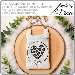 May include: White crossbody phone bag with a gold chain strap. The bag features a leopard print heart design with the word "Love" embroidered below. The bag has a zipper closure and a textured brick pattern.