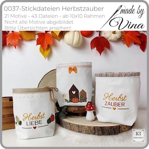 Könnte beinhalten: Drei weiße Stoffbehälter mit Herbststickereien. Einer hat "Herbst Liebe" und Kürbisse, ein anderer ein Hausdesign und der dritte sagt "Herbst Zauber". Die Behälter sind mit Spitze, Schleifen und einer Pilzfigur verziert.