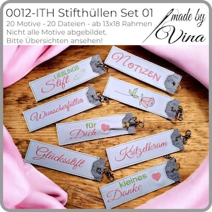 Peut inclure: Ensemble de porte-stylos brodés avec des phrases allemandes en fil rouge et vert. Chaque porte-stylo a une extrémité en feutre gris et un fermoir en métal. Phrases incluant "für Dich" et "kleines Danke". Fond en bois.