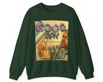 May include: Dark green sweatshirt featuring a graphic of a person in a car with the words "GOOD DAY" in a 3D font. The graphic is in a rectangular frame. The sweatshirt is a solid color.