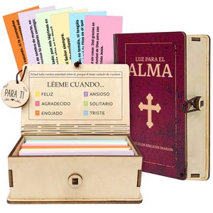 May include: A wooden box with a hinged lid, containing colorful cards and a small wooden tag that says "Para Ti". A maroon book with the words "Luz Para El Alma" and a cross is next to the box. The box has the words "LÉEME CUANDO..." on it.