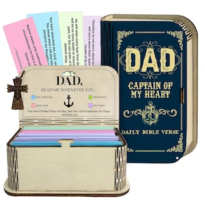 May include: A wooden box with a hinged lid and a compartment for cards. The box is engraved with the words "DAD, READ ME WHENEVER YOU..." and "DAD, CAPTAIN OF MY HEART." The box contains colourful cards with Bible verses.