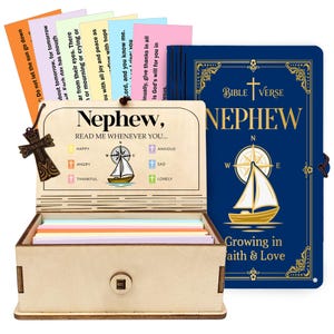 May include: A wooden box set with colourful cards and a blue Bible Verse book. The box is engraved with "Nephew, READ ME WHENEVER YOU..." and a sailboat graphic. The book says "Nephew" and "Growing in faith & Love".