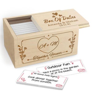 May include: A wooden "Box of Dates" with a sliding lid, engraved with hearts, names, and a date. The box features a heart with initials and the words "Together Forever." Two cards with date night ideas are visible.