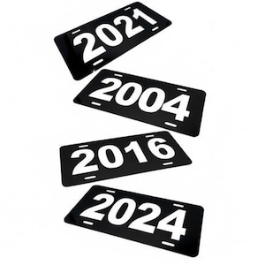 May include: Four black license plates with white text displaying the years 2021, 2004, 2016, and 2024. The plates are rectangular with rounded corners and white accent lines.