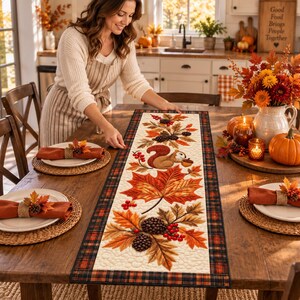 Può includere: Un runner da tavola rettangolare con un pannello centrale color crema caratterizzato da un motivo autunnale stampato con scoiattolo, foglie d'acero, pigne e bacche rosse, bordato da una finitura in tessuto scozzese scuro.