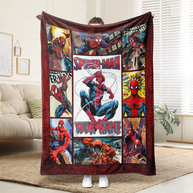 Op de afbeelding: Een rood-blauwe Spider-Man deken met stripboekpanelen en de tekst "Spider-Man" en "Your Name". De deken heeft een donkerrode rand en een verscheidenheid aan Spider-Man actieposes.