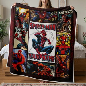 Op de afbeelding: Een grote, rechthoekige Spider-Man-deken met meerdere stripboekpanelen. Het centrale paneel toont Spider-Man in een dynamische pose met de tekst "YOUR NAME". De deken is overwegend rood, blauw en zwart.