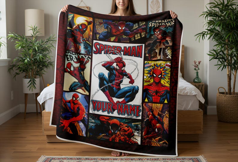 Op de afbeelding: Een grote, rechthoekige Spider-Man-deken met meerdere stripboekpanelen. Het centrale paneel toont Spider-Man in een dynamische pose met de tekst "YOUR NAME". De deken is overwegend rood, blauw en zwart.