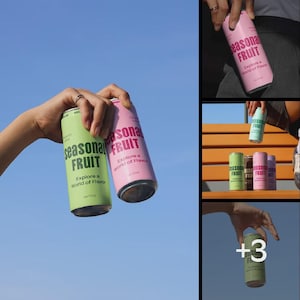 May include: Two aluminum cans of "Seasonal Fruit" drink, one green and one pink, are held against a blue sky. The cans have the text "Explore a World of Flavor". The image is a collage of multiple shots of the cans.