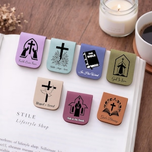 Könnte beinhalten: Eine Sammlung von Leder-Lesezeichen mit religiösen Motiven. Jedes Lesezeichen zeigt ein Kreuz, eine Kirche oder eine Bibelillustration mit Sätzen wie „Glaube über Angst“ und „Gottes Segen“. Die Lesezeichen sind in verschiedenen Farben erhältlich, darunter Lila, Blau und Braun.