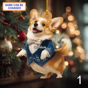 May include: A corgi dog Christmas ornament, wearing a blue tuxedo and a white bow tie. The name "Adam" is on the jacket. The text "NAME CAN BE CHANGED" is at the top. A gold string is attached for hanging.