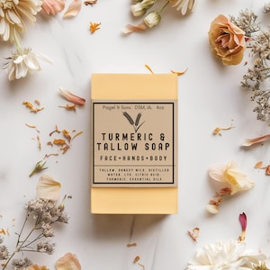 May include: A yellow rectangular bar of turmeric and tallow soap with a brown label, surrounded by flowers and petals. The label reads "Turmeric & Tallow Soap" and lists ingredients. The soap weighs approximately 113 grams.