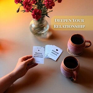 Endless Nights couples conversation starter cards being played at home with tea, flowers, and cozy setting. Card reads “What do you need more of in our relationship?” Perfect printable game for couples to deepen connection, improve communication, and spark intimacy. Designed for dating, engaged, or married partners as a romantic before-bed activity. Fun 30-day challenge with thoughtful questions for anniversaries, date nights, or long distance relationships.