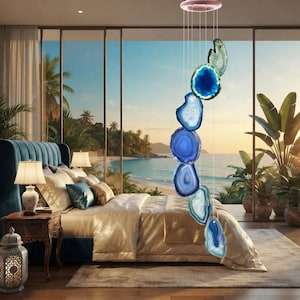 May include: A vertical mobile wind chime featuring seven polished, translucent agate slices in varying shades of blue and teal, suspended by thin clear strings from a circular top mount, creating a cascading arrangement of natural stone.