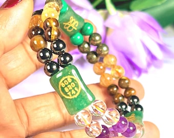 May include: A double-strand beaded bracelet featuring a variety of gemstones including tiger's eye, hematite, amethyst, citrine, and pyrite. It includes two green rectangular beads, one with a gold symbol and one with the text 808 520 741.