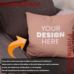 a brown couch with a pink pillow on it. The pillow has the text "YOUR DESIGN HERE" printed on it.
