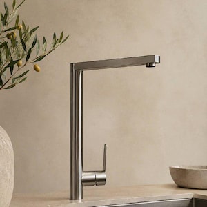 Puede incluir: Un grifo de cocina alto de acero inoxidable cepillado con un diseño elegante en forma de L. El grifo cuenta con una palanca vertical única situada en la base para controlar el agua y un caño horizontal largo sobre un fregadero de acero.