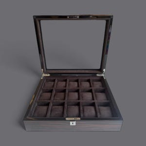 Könnte beinhalten: Geöffnete Uhrenvitrine aus Holz mit Glasdeckel. Der Innenraum verfügt über sechzehn einzelne Fächer mit braunen Samtkissen. Das Gehäuse hat eine dunkle Holzmaserung und einen silberfarbenen Verschluss.