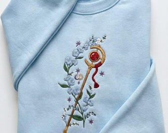 Felpa ricamata con fiori blu, regalo per amanti dei libri, girocollo con bacchetta magica anime ricamata, maglietta con spada e bastone, maglietta con bacchetta magica anime