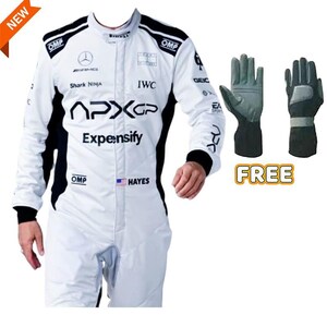 Puede incluir: Mono de carreras blanco con detalles negros, con logotipos de patrocinadores y el texto "APXGP" y "Expensify." Incluye un par de guantes de carreras grises y negros. El mono tiene el nombre "HAYES" y una peque&ntilde;a bandera americana. La palabra "NEW" est&aacute; en la esquina superior izquierda.