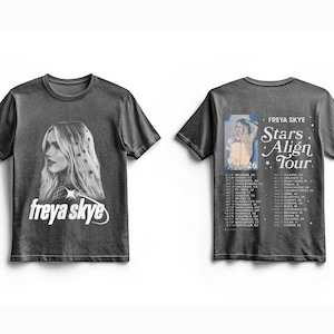 May include: Dark gray t-shirt featuring a side profile of Freya Skye with the text "freya skye" in white. The back of the shirt has a photo of Freya Skye and the text "Stars Align Tour 26" with a list of tour dates.