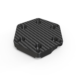 Op de afbeelding: Een zeshoekige plaat met een zwart en grijs koolstofvezel weefpatroon op het bovenoppervlak. De plaat bevat zes cirkelvormige verzonken gaten in een symmetrisch patroon, met een effen zwart zijprofiel en een vlakke onderkant.