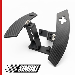 May include: Two black carbon fibre paddle shifters with a textured weave pattern. One paddle has a minus symbol, the other a plus symbol. The shifters are mounted on black brackets. The logo "SIMUKI" is at the bottom.