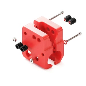 May include: A bright red, two-piece mechanical block component featuring multiple circular cutouts and hexagonal holes. The assembly includes several small black threaded set screws, two thin metal bolts, two silver hexagonal nuts, and a red washer.